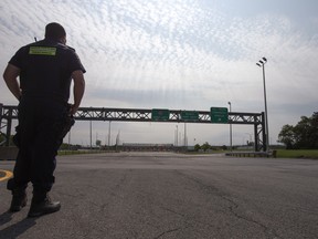 A Canadian border agent stands guard at the Canada-U.S. border in Saint-Bernard-de-Lacolle, Quebec.