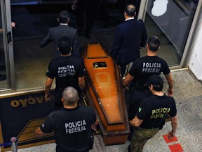 One of the coffins containing human remains found during the search for missing British journalist Dom Phillips and indigenous expert Bruno Pereira in the Amazon forest, is carried upon arrival at the Federal Police hangar in Brasilia on June 16, 2022.