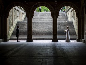 A bride and groom pose for wedding pictures at the Bethesda Terrace in New York's Central Park on Tuesday, May 23, 2017.