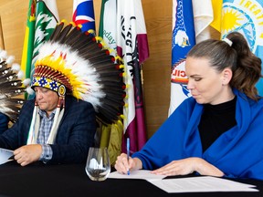 Saskatoon Tribal Council Chief Mark Arcand (left) and Discover Saskatoon CEO Stephanie Clovechok (right) signed a partnership agreement on behalf of their respective organizations on June 15, 2022.  (Sik Pics Productions/Discover Saskatoon)