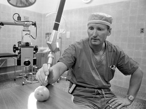 A photo of Dr. Stanley Valnicek demonstrating a new surgical laser at City Hospital by cutting designs into a tomato, from July 14, 1983.