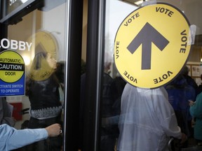 Voters wait in line to cast their ballots both inside and outside the SHOAL Centre on election day in Sidney, B.C., Monday, Oct. 19, 2015. Elections Canada has issued 14 fines related to campaign fundraising and finances during the 2019 federal election.THE CANADIAN PRESS/Chad Hipolito