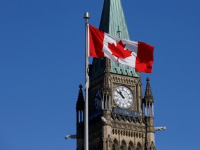 A Canadian flag in front of the Peace Tower on Parliament Hill in Ottawa.