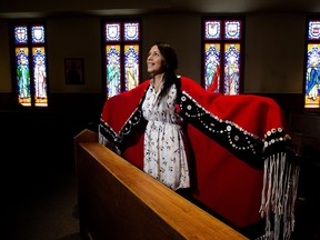Visual artist, traditional powwow dancer and a member of the Nisga'a Nation, Julia Kozak poses with one of her traditional button blankets in a chapel at the Catholic Archdiocese of Edmonton, Thursday July 21, 2022. Kozak designed the vestments to be worn by Pope Francis during mass at Commonwealth Stadium.