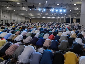 Worshippers continue with prayer by bowing on their hands and knees to Allah at Prairieland Park in Saskatoon for Eid al-Adha on July 9, 2022.