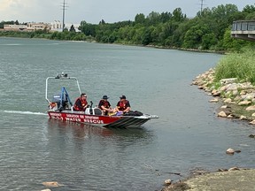 Firefighters from the Saskatoon Fire Department travel in a water rescue boat on the South Saskatchewan River as part of a protest in Saskatoon on July 19, 2022. (Thia James/Saskatoon StarPhoenix).