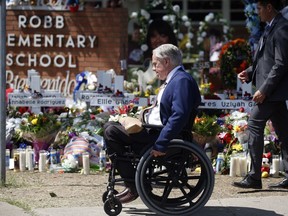 Texas Governor Greg Abbott passes in front of a memorial outside Robb Elementary School to honour the victims killed in a school shooting in Uvalde, Texas, May 29, 2022.
