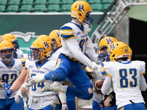 Saskatoon Hilltops receiver Lachlan Horsley (87) leaps into the air to celebrate with quarterback Damon Dutton (19) after Dutton ran the ball over the goal line for a touchdown during the Prairie Football Conference championship game against the Regina Thunder at Mosaic Stadium in Regina, Saskatchewan on Nov. 14, 2021. BRANDON HARDER/ Regina Leader-Post