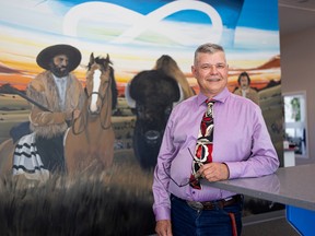 Métis Nation-Saskatchewan Economic Development and Tourism Minister Brent Digness stands for a photo in front of a mural at the Métis Nation-Saskatchewan office on 19th Street West in Saskatoon, July 12, 2022.