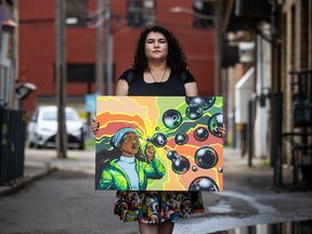 Ailah Carpenter poses with their painting outside the Drinkle building, where their artwork is being added this week. Photo taken in Saskatoon, SK on Tuesday, August 2, 2022.