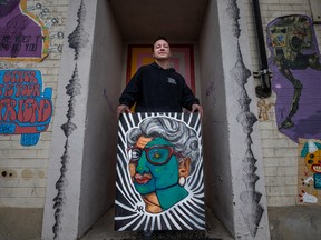 Noah Roy stands with his painting Ethereal Ethal outside the Drinkle building art wall, where their artwork is being added this week. Photo taken in Saskatoon, SK on Tuesday, August 2, 2022.
