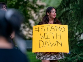 A participant holds a sign in support of Dawn Walker at the Vimy Memorial Bandshell in Saskatoon on Aug. 7, 2022.