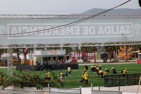 Staff members clean the venue of Medusa Festival, an electronic music festival, after high winds caused part of a stage to collapse, in Cullera, near Valencia, Spain, Saturday, Aug. 13, 2022.