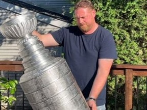 Shawn Wilson hoists his 3-D printer version of the Stanley Cup.
