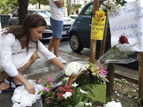 A woman places a bouquet of flowers where Nigerian street vendor Alika Ogorchukwu was murdered, in Civitanova Marche, Italy, Saturday, July 30, 2022.