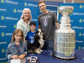 Christine Martin, her therapy dog ​​Odin, Evelyn Martin, and Abraham Martin alongside Washington Capitals Stanley Cup champion goaltender Darcy Kemper and Stanley Cup at the Saskatoon Police Service's gymnasium on August 5, 2022 I am taking pictures.