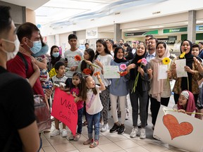 Afghan refugees sing as they welcome friends at Saskatoon International Airport on August 27, 2022.