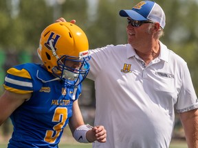 Saskatoon Hilltops head coach Tom Sargeant talks to quarterback Trey Reider (3) during CJFL action. The Hilltops defeated the Winnipeg Rifles 19-10 in Saskatoon on Sunday, Aug. 14, 2022.