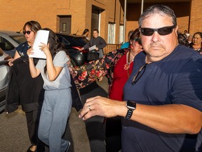 A Saskatoon woman accused of kidnapping a child and fleeing to the U.S. covers her face as supporters help her to a vehicle after she was released on bail from the Provincial courthouse in Saskatoon on Sept. 2, 2022.