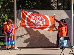 The Survivors' Flag is held during the unveiling of the Survivors' Flag and Orange Banner Project in Saskatoon, Sept. 26, 2022.