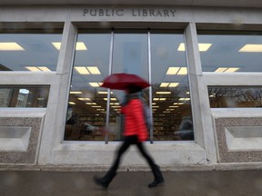 A woman walks past the Frances Morrison Central Library in downtown Saskatoon. The Saskatoon Public Library board approved this summer a sale of the building, in advance of the opening of a new central branch anticipated in 2026.