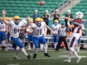 Regina Thunder quarterback Carter Shewchuk flips a pass over Josh Dunham, 64, and Daylen Hartz, 76, of the Saskatoon Hilltops on Saturday at Mosaic Stadium.