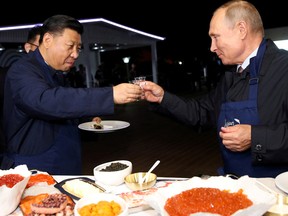 Russian President Vladimir Putin and Chinese President Xi Jinping toast during a visit to the Far East Street exhibition on the sidelines of the Eastern Economic Forum in Vladivostok, Russia September 11, 2018.