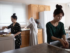 From left, Rejna Ahmadi, her mom Zubida Yousfi and sister Shakiba Ahmadi prepare a comforting meal of bulani in the kitchen of their new home in Saskatoon on Jan. 17, 2022.