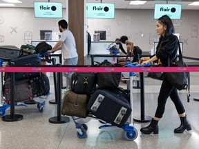 Shakiba Ahmadi (right) pushes her luggage through the line at the Saskatoon International Airport on Aug. 27, 2022.
