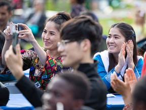 Sisters Shakiba Ahmadi (left) and Rejna Ahmadi applaud their friends, singers from Afghanistan, who performed at the Fringe Festival in Saskatoon on Aug. 3, 2022.