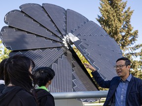 Jerry Chwang, head of Microgrid Solutions, explains how the Smartflower microgrid (MG) follows the sun, absorbing energy and providing power for one of the classrooms at Bishop James Mahoney High School. Photo taken in Saskatoon on Sept. 22, 2022.