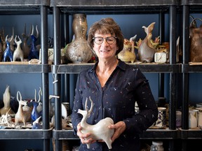 Paula Cooley stands in her home studio with one of her sculptures. (Michelle Berg)