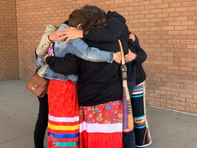 Megan Gallagher's family, friends and supporters gather for a hug outside of Saskatoon provincial courthouse where one of the eight people accused had a scheduled court appearance on Monday, Oct. 3, 2022.