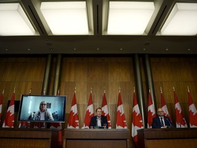 Minister of Crown-Indigenous Relations Marc Miller, centre, Minister of Justice David Lametti and and Minister of Indigenous Services Patty Hajdu, appearing via video conference at left, participate in a news conference regarding the order from the Canadian Human Rights Tribunal to compensate Indigenous children and their families, in Ottawa, on Friday, Oct. 29, 2021.