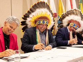 From left to right, Minister of Corrections, Policing and Public Safety Christine Tell, Saskatoon Tribal Chief Mark Arcand and Whitecap Dakota First Nation Chief Darcy Bear sign the papers for a transitional support program that helps women released from jail reintegrate into the community.