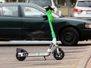 A Lime e-scooter is seen parked in a car parking spot in downtown Edmonton. The City of Saskatoon is expected to issue a request for proposals ahead of a spring 2023 pilot program to bring two e-scooter companies to Saskatoon, with a combined fleet of 500 e-scooters.