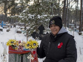 Victoria Beatty kneels beside the grave of her father, Stanley Durocher. This year, a new marker honours her father's service in the Second World War.