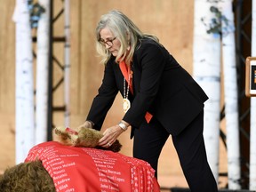 Marie Wilson, former commissioner of the Truth and Reconciliation Commission, places a bundle of beaver skin on the ceremonial cloth with the names of 2,800 children who died in residential schools and were identified in the National Student Memorial Register, during the Honouring National Day for Truth and Reconciliation ceremony in Gatineau, Quebec on Monday, Sept. 30, 2019.