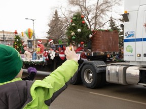 Santa Parade float drivers and kids waving in the crowd on Sunday in Saskatoon.