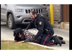 A screengrab of a bystander's video recording of a man's arrest on 22nd Street West in Saskatoon on Nov. 1, 2022.
