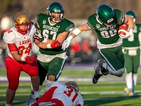 Caleb Morin jumps out of the grip of Laval's Hugo Larue for extra yards on a drive that ended with a Laval interception, ending the hopes of the Huskies in the Vanier Cup in London, Ont on Saturday.