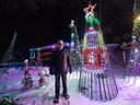Scott Lambie se tient à côté de sa partie préférée de son affichage élaboré des lumières de Noël - un Mariah Carey Santa Claus programmé qui danse avec son célèbre 