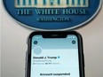 A photo illustration shows the suspended Twitter account of U.S. President Donald Trump on a smartphone at the White House briefing room in Washington, D.C., Jan. 8, 2021.