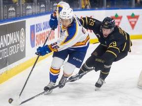 Saskatoon Blades centre Trevor Wong (38) carries the puck under pressure from Brandon Wheat Kings centre Nate Danielson (29) during first-period WHL action in Saskatoon on Tuesday, December 6, 2022.
