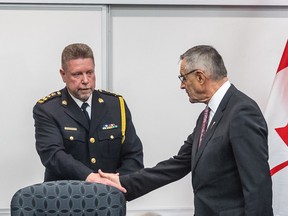 Police chief Troy Cooper, left, shakes hands with Minister of Crown Investments Corporation Don Morgan at a press conference to announce $7.38 million in provincial police funding.