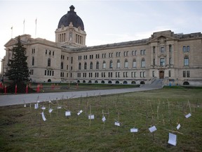 An installation of protest art, consisting of wooden crosses, some with bits of text attached, is seen in front of the Saskatchewan Legislative Building in Regina, Saskatchewan on Oct. 18, 2021. New data shows Saskatchewan is on course to record an even higher number of deaths to the pandemic in 2022.