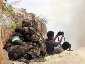 In this file photo taken on May 15, 2007, African Union peacekeepers take cover as two Somali photographers point their cameras towards the site where the troops were detonating seized ammunition in Mogadishu.