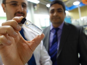 Two men, one holding vial with suspended glitter