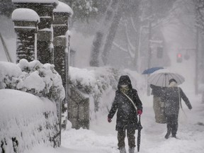 People make their way in the heavy snow in Kanazawa, Ishikawa Prefecture, central Japan in this photo taken by Kyodo on December 23, 2022.