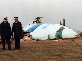 In this file photo taken on Dec. 22, 1988, policemen stand near the wreckage of the 747 Pan Am airliner that exploded and crashed over Lockerbie, Scotland.